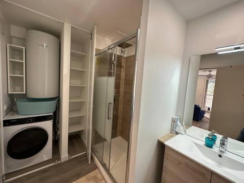 une salle de bain avec douche et machine à laver dans l'établissement T3 Grand Standing 65m2, vue mer, parking privé et à 200m des plages, à Collioure
