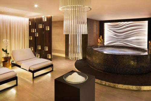 a bathroom with a tub with a chair and a couch at Sheraton Grand Hotel, Dubai in Dubai