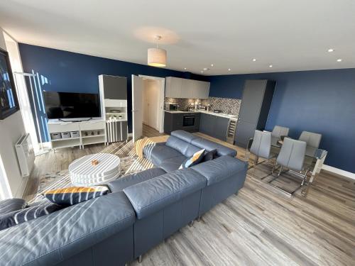 Sala de estar azul con sofá y cocina en Apartment in Ashford with Large Terrace en Ashford