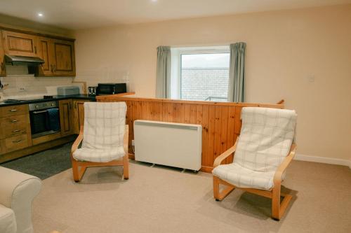 a kitchen with two chairs and a counter top at Granary at Tyddyn Isaf in Ruthin