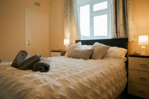 um quarto com uma grande cama branca e uma janela em Granary at Tyddyn Isaf em Ruthin
