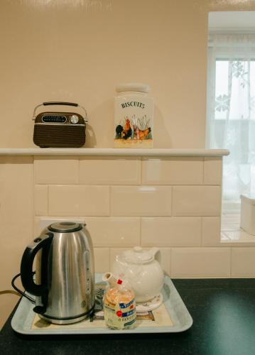 a tea kettle on a tray on a kitchen counter at Granary at Tyddyn Isaf in Ruthin