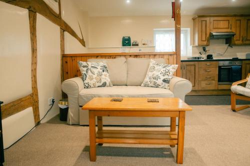 uma sala de estar com um sofá e uma mesa em Granary at Tyddyn Isaf em Ruthin