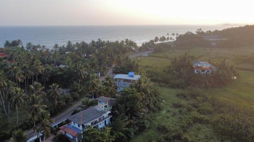 an aerial view of a house on a hill next to the ocean at Mango Shade in Dickwella