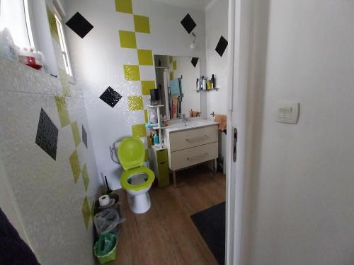 a bathroom with a yellow toilet and a sink at Une chambre presque en ville in Quimper