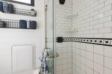 a bathroom with a toilet and a glass door at The Blue Ridge "Romantic" Tiny Home Near Magnolia & Baylor in Bellmead