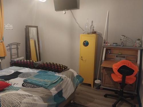 a bedroom with a bed and a desk and a mirror at Une chambre presque en ville in Quimper