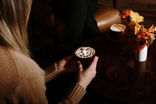 a woman sitting at a table holding a doughnut at Taos Valley Lodge in Taos