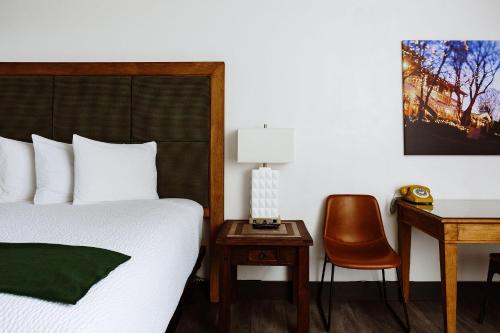 a bedroom with a bed and a desk and a chair at Taos Valley Lodge in Taos