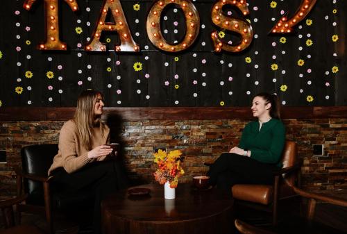 two women sitting in a bar with a table at Taos Valley Lodge in Taos