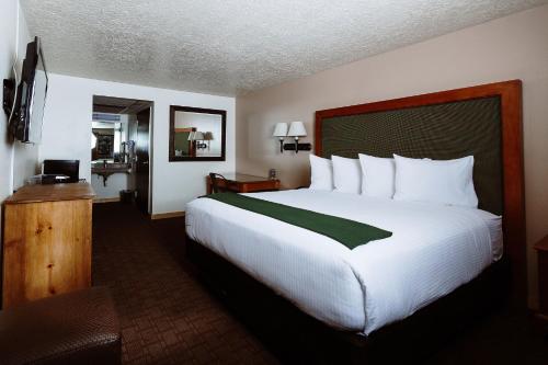 a hotel room with a large bed with white pillows at Taos Valley Lodge in Taos
