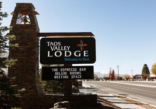 a sign for the tacs valley lodge with a street at Taos Valley Lodge in Taos