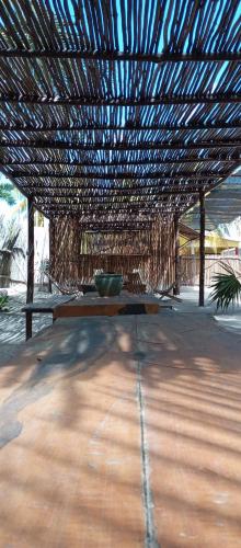 a table under a straw roof with a bowl on it at El Regalo El Cuyo in El Cuyo