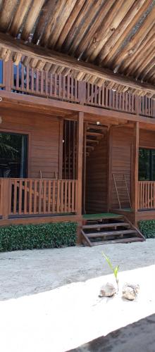 a wooden house with two plants in front of it at El Regalo El Cuyo in El Cuyo