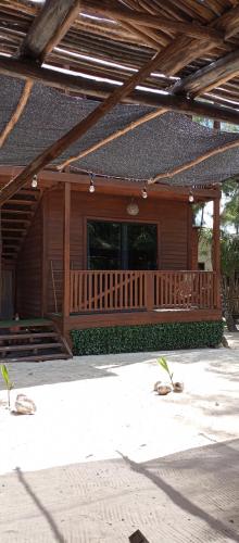 a wooden cabin with a porch and a large window at El Regalo El Cuyo in El Cuyo