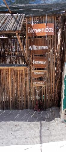 a sign on the side of a bamboo building at El Regalo El Cuyo in El Cuyo