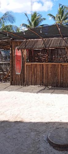 a wooden fence with a red kayak on the beach at El Regalo El Cuyo in El Cuyo