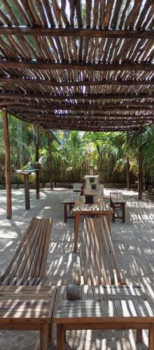 a group of benches under a wooden pergola at El Regalo El Cuyo in El Cuyo
