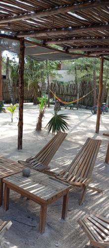 two wooden benches sitting under a pavilion at El Regalo El Cuyo in El Cuyo
