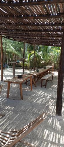 a group of picnic tables sitting under a wooden structure at El Regalo El Cuyo in El Cuyo
