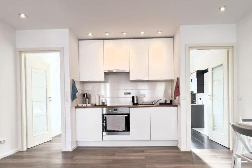 a kitchen with white appliances and white cabinets at Fühle dich wie zu Hause im Taunus in Flörsheim am Main