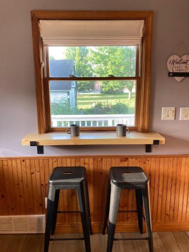 two black stools sitting in front of a window at Cozy Algoma Retreat! Minutes to Beach and Downtown! in Algoma