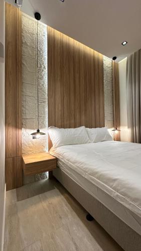 a bedroom with a large bed with a wooden headboard at شقه مترفه النخيل ٣ in Riyadh