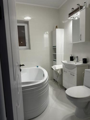 a bathroom with a tub and a toilet and a sink at Best Apartment Suceava in Suceava