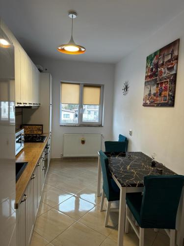 a kitchen with a table and chairs in a kitchen at Best Apartment Suceava in Suceava