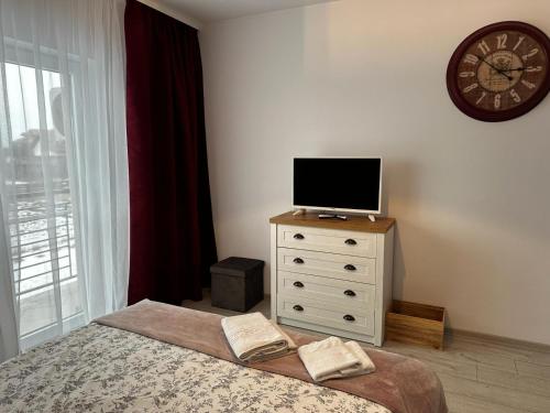 a bedroom with a bed and a tv on a dresser at Best Apartment Suceava in Suceava