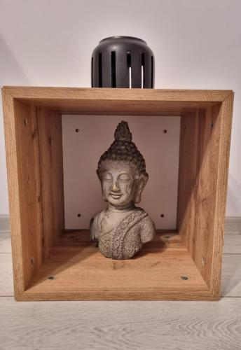 a small wooden box with a buddha statue in it at Best Apartment Suceava in Suceava