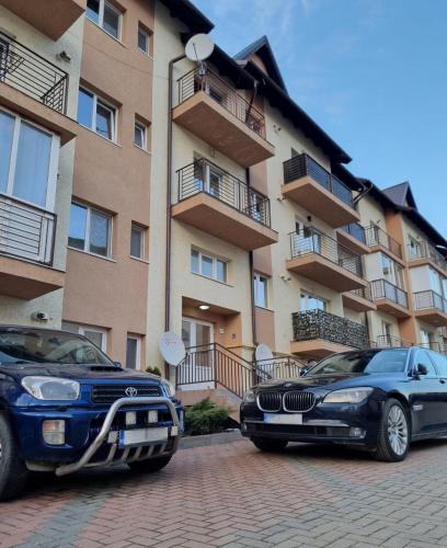 two cars parked in front of a building at Best Apartment Suceava in Suceava