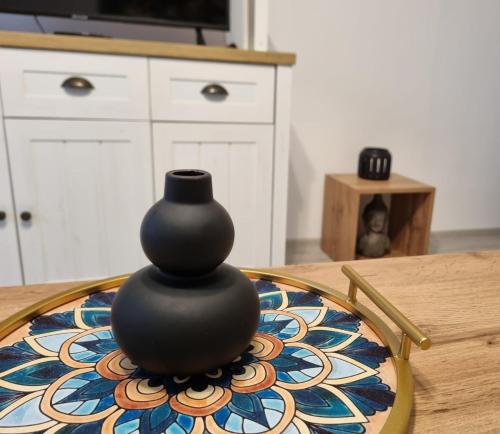 a black vase sitting on top of a table at Best Apartment Suceava in Suceava