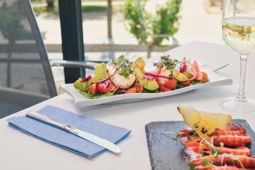 a table with a plate of food and a glass of wine at Calipolis in Sitges