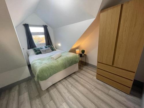 niewielka sypialnia z łóżkiem i oknem w obiekcie Modern apartment next to airport w mieście Marston Green