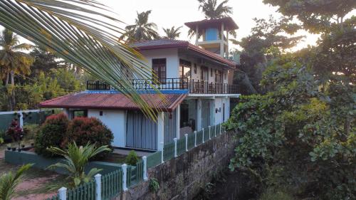 a house on a hill with a palm tree at Mango Shade in Dickwella
