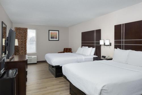 a hotel room with two beds and a flat screen tv at Stay 2Night Chattanooga Hamilton Place in Chattanooga
