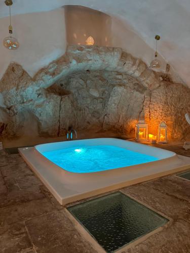 a large blue tub in a stone walled bathroom at Arquati Suite Luxury Apartment in Ostuni