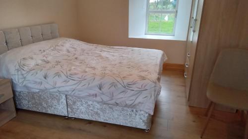 a small bed in a room with a window at Boola Cottage in Browns Cross Roads