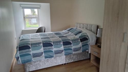 a bedroom with a bed and a desk and a window at Boola Cottage in Browns Cross Roads