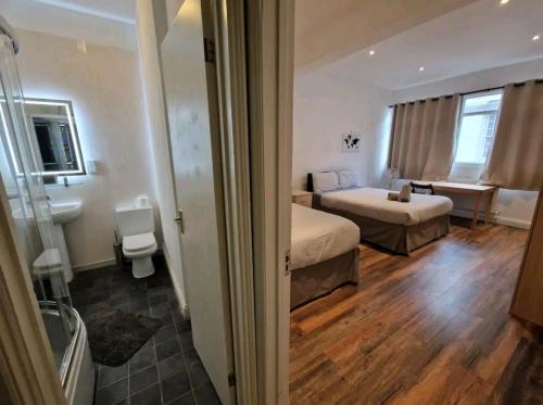 Affordable Rooms in shared flat, London Bridge في لندن: غرفة نوم بسريرين وحمام مع حوض