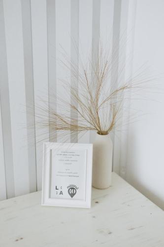a white vase and a box on a table with a plant at Penzion Jakub in Lanškroun