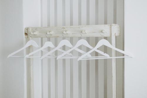 a white closet organizer with four white hangers at Penzion Jakub in Lanškroun