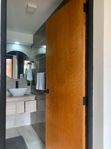 a bathroom with a wooden door and a sink at San fason 3 in Bogotá