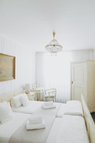 a white room with two beds and a table at Penzion Jakub in Lanškroun