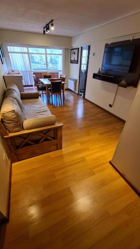 uma sala de estar com um sofá e uma televisão de ecrã plano em Apartamento Urquiza em San Carlos de Bariloche