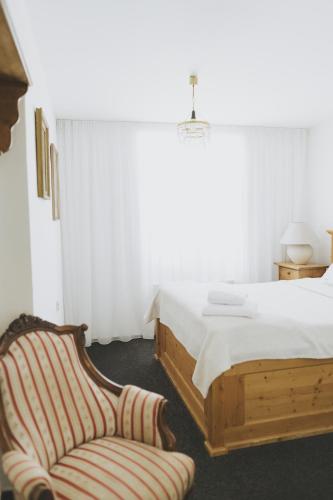 a bedroom with a bed and a chair at Penzion Jakub in Lanškroun