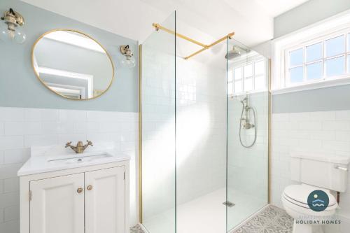 a bathroom with a shower and a sink and a mirror at Comfort Hill - Luxury hot tub sea views in Overcombe