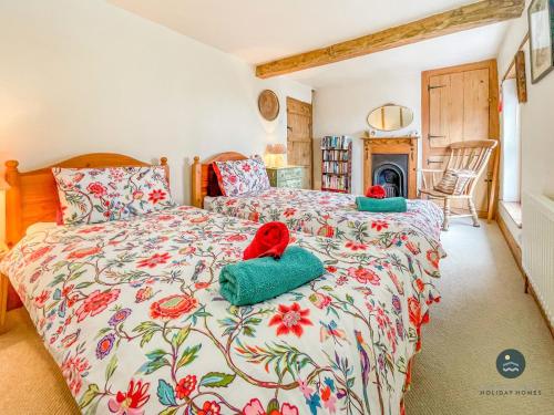 a bedroom with two beds with towels on it at Rope Cottage - traditional cottage close to town in Bridport
