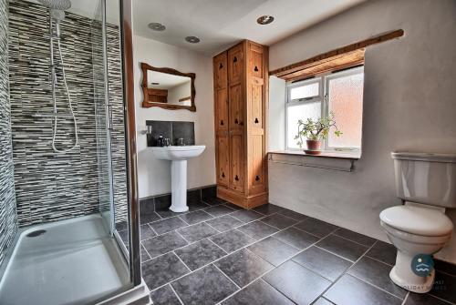a bathroom with a toilet and a sink and a shower at Rope Cottage - traditional cottage close to town in Bridport